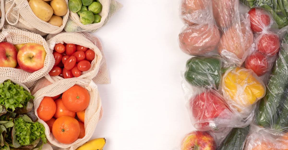 Eco-friendly bags filled with fresh produce sit on one side of a table, and plastic bags with produce sit on the other side.